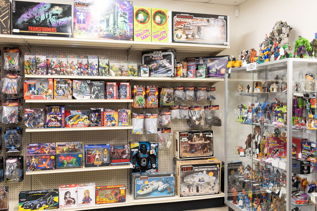 A glass case of loose action figures and collectibles at The Toy Outpost.
