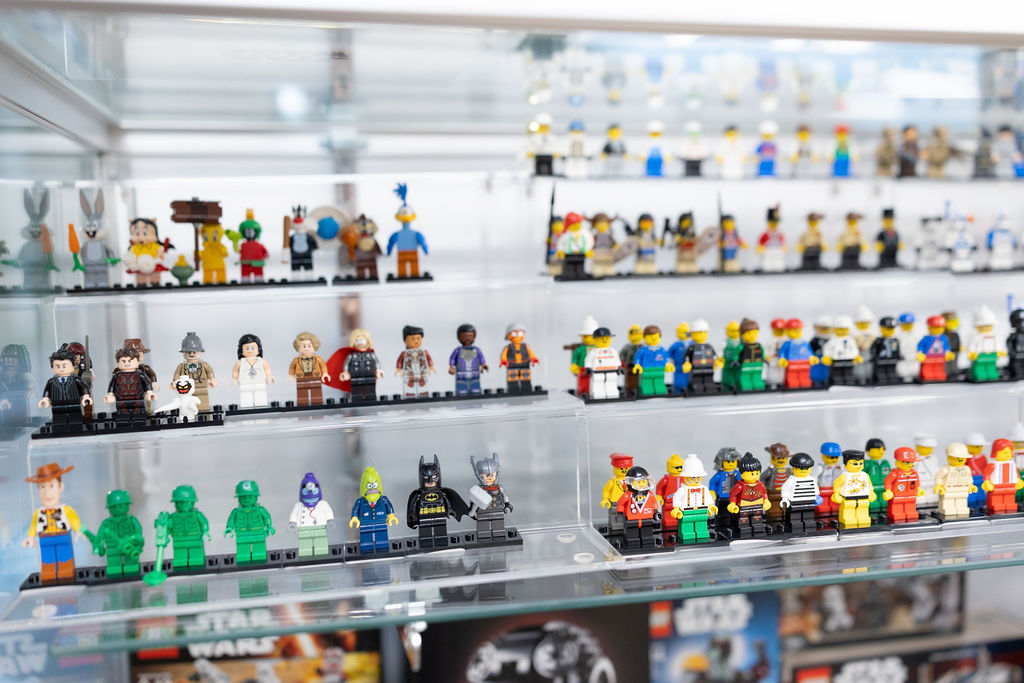 A dense display of LEGO minifigures in a glass case.