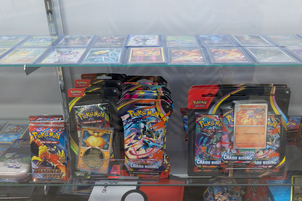 Pokémon TCG singles and sealed packs in a glass case.